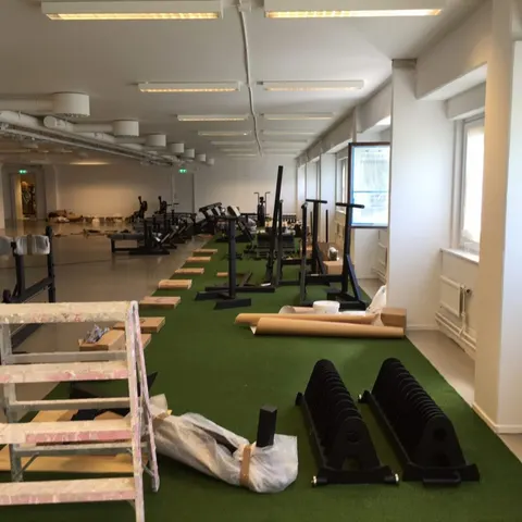 Den nya gymlokalen under inredning, med konstgräs och ställningar på plats.