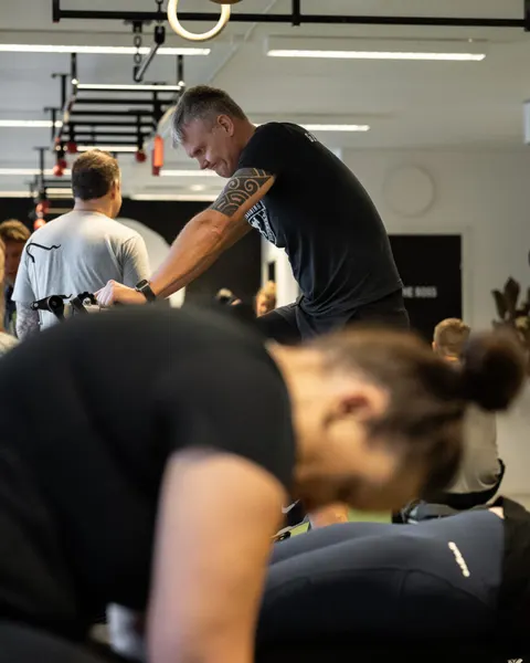 En coach instruerar medlemmar under ett pass i gymmet.