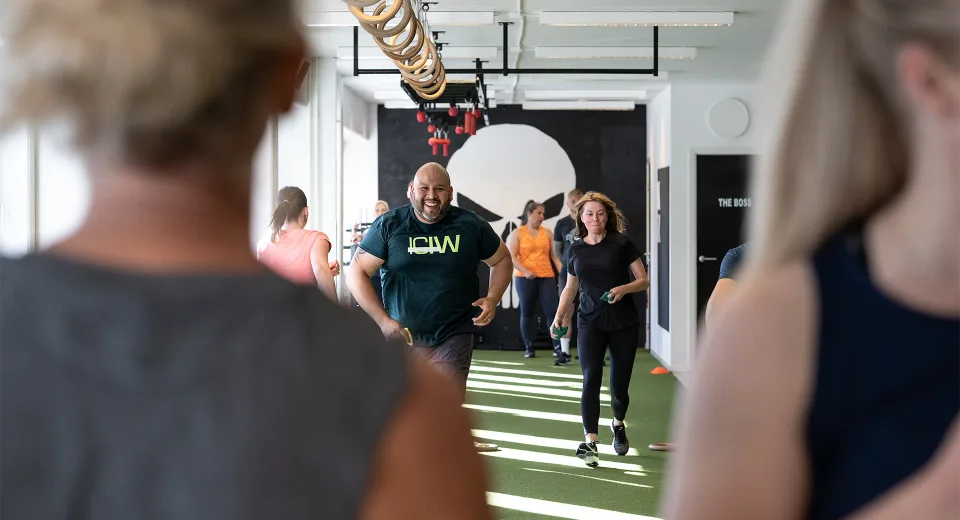 Medlemmar tränar tillsammans på gymmets gröna konstgräsbana.